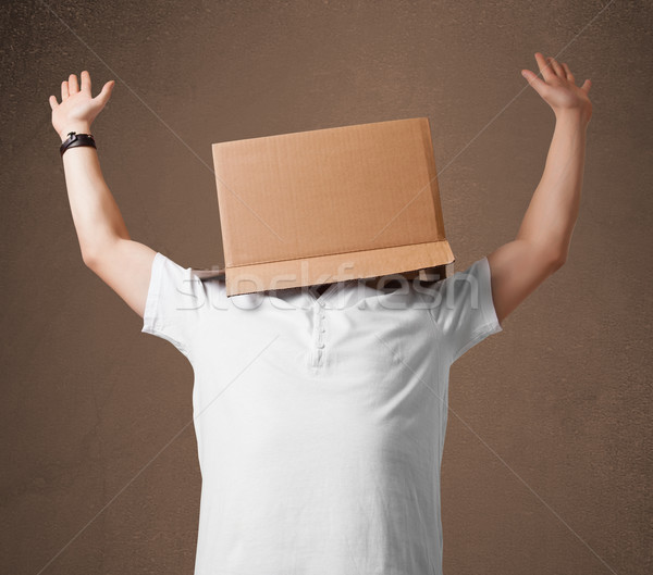 Young man gesturing with a cardboard box on his head Stock photo © ra2studio