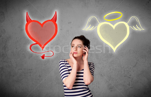 Woman standing between the angel and devil hearts Stock photo © ra2studio