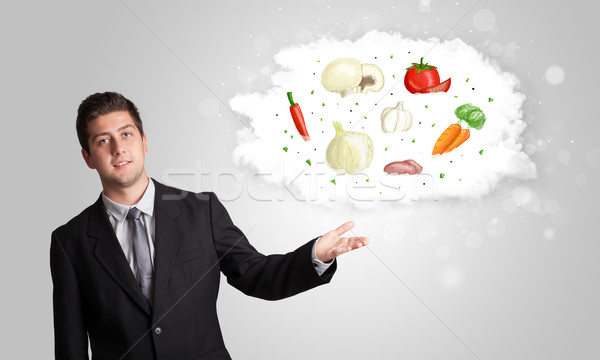 Handsome man presenting a cloud of healthy nutritional vegetable Stock photo © ra2studio