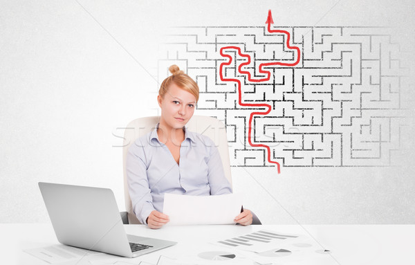Business woman at desk with labyrinth and arrow Stock photo © ra2studio