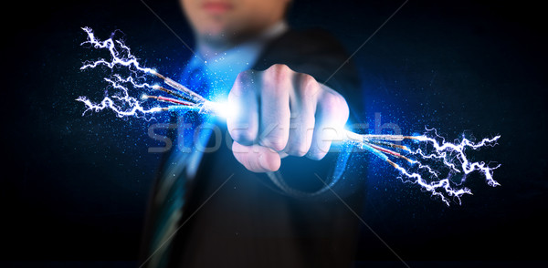 Business person holding electrical powered wires Stock photo © ra2studio