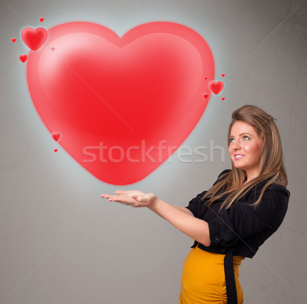 Young lady holding lovely 3d red heart Stock photo © ra2studio