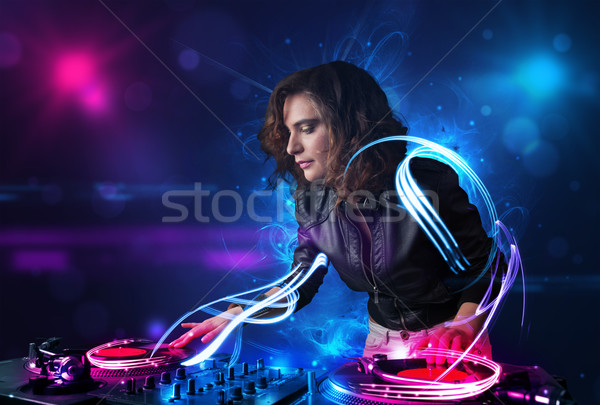 Disc jockey playing music with electro light effects and lights Stock photo © ra2studio