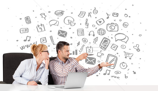Young businessman and businesswoman with all kind of hand-drawn icons in background Stock photo © ra2studio