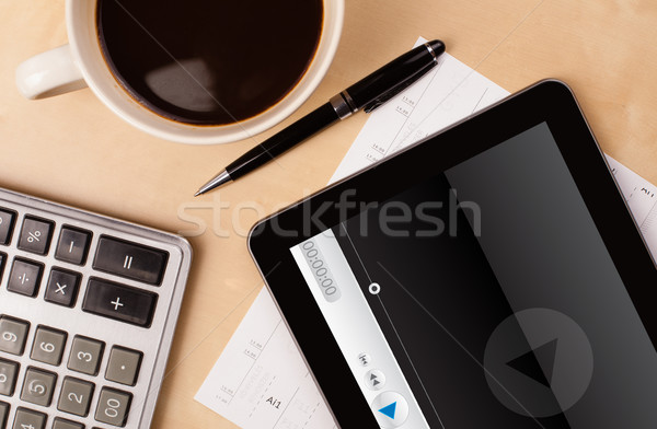 Workplace with tablet pc showing media player and a cup of coffee on a wooden work table closeup Stock photo © ra2studio