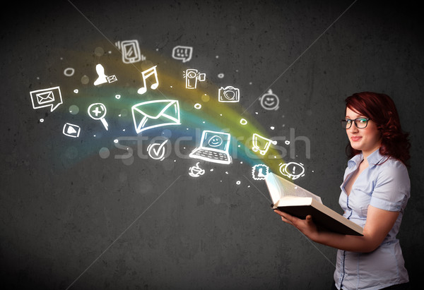 Stock photo: Young woman reading a book with multimedia icons coming out of t