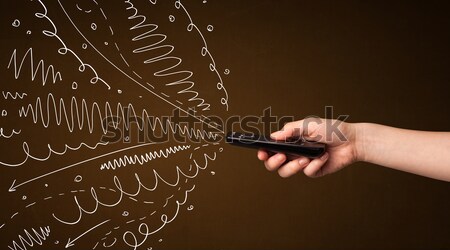 Hand with remote control and curly lines Stock photo © ra2studio