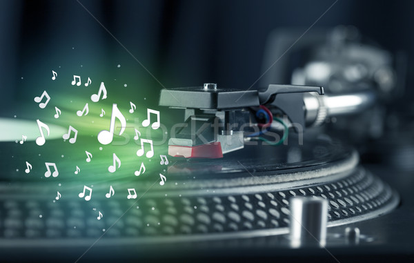 Turntable playing music with audio notes glowing Stock photo © ra2studio