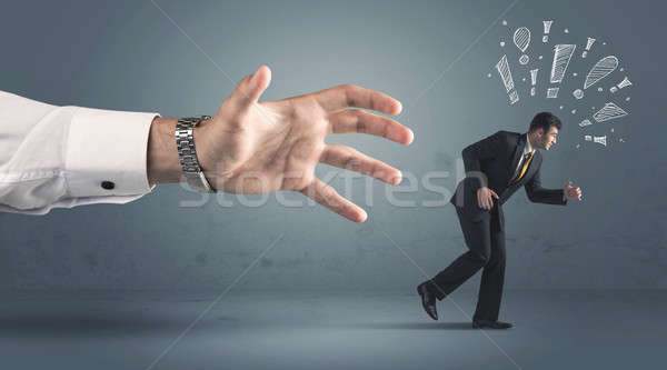 Business person getting away from a big hand Stock photo © ra2studio