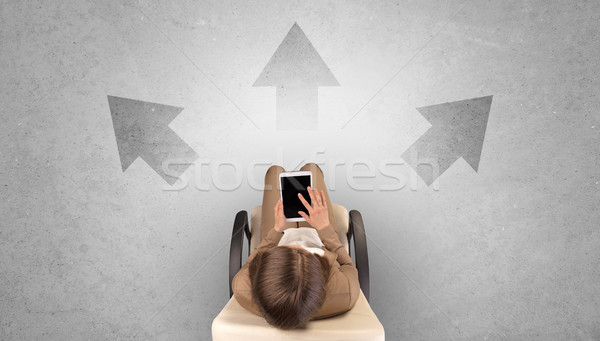 Stock photo: Woman sitting in office with device an her hand