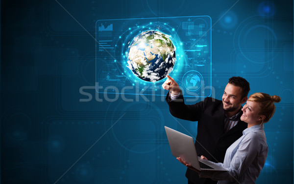 Young couple touching high-tech 3d earth panel Stock photo © ra2studio