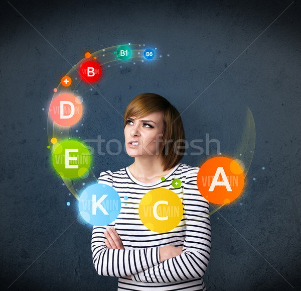 Young woman thinking with vitamins circulation around her head Stock photo © ra2studio