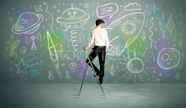 Young businessman drawing rocket Stock photo © ra2studio