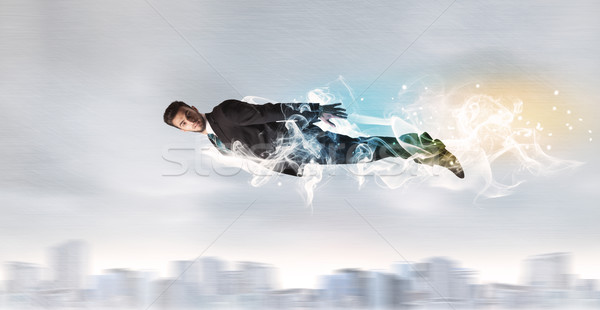 Hero superman flying above city with smoke left behind Stock photo © ra2studio