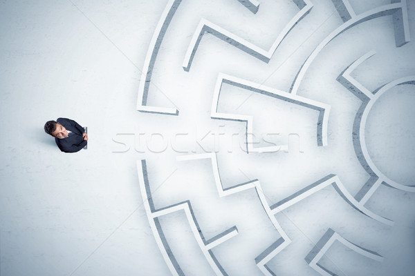 Stock photo: Business man looking at circular maze with nowhere to go