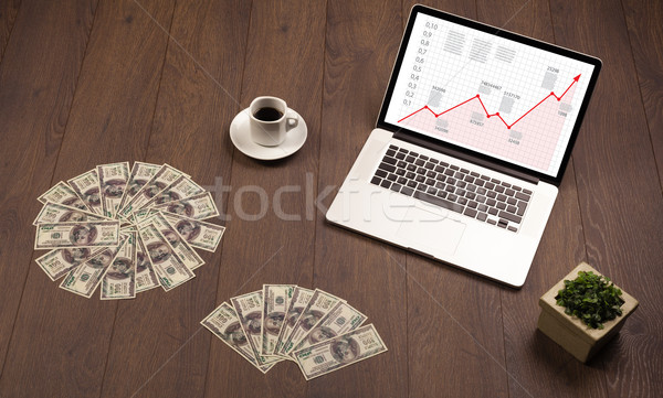 Computer desk with laptop and red arrow chart in screen Stock photo © ra2studio