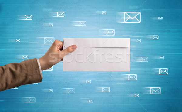 Hand holding envelope with message symbols around Stock photo © ra2studio