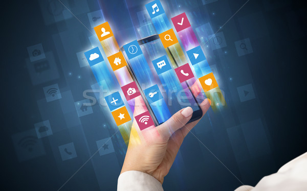 Hand using smartphone with angular app icons Stock photo © ra2studio
