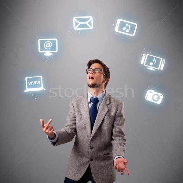 Stock photo: funny boy juggling with electronic devices icons