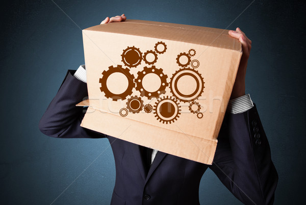 Businessman gesturing with a cardboard box on his head with spur Stock photo © ra2studio