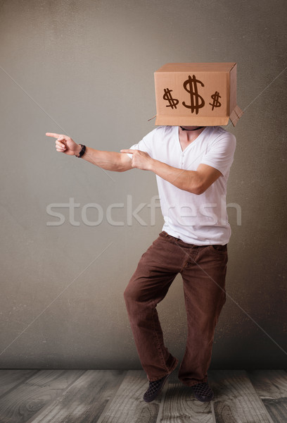 Young man gesturing with a cardboard box on his head with dollar Stock photo © ra2studio