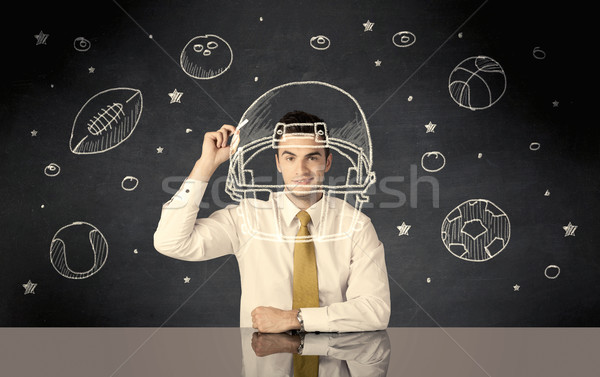 Businessman drawing helmet and sport balls Stock photo © ra2studio