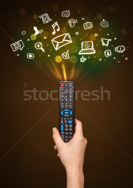 Hand with remote control and social media icons Stock photo © ra2studio