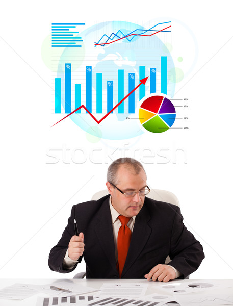 Stock photo: Businessman sitting at desk with statistics