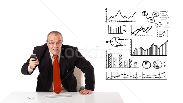 Businessman sitting at desk with diagrams and graphs Stock photo © ra2studio