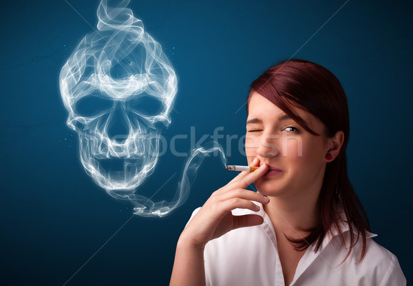 Young woman smoking dangerous cigarette with toxic skull smoke  Stock photo © ra2studio