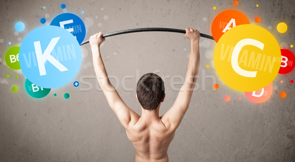 skinny guy lifting colorful vitamin weights Stock photo © ra2studio