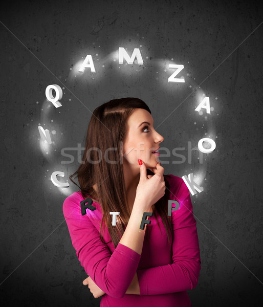 Stock photo: Young woman thinking with letter circulation around her head