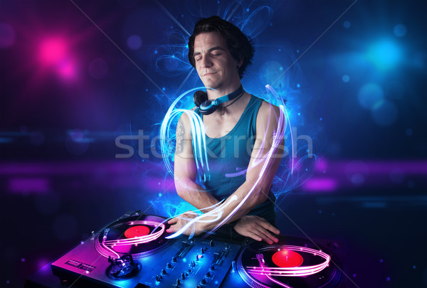 Disc jockey playing music with electro light effects and lights Stock photo © ra2studio