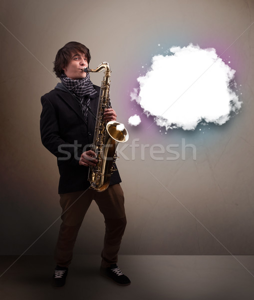 Young man playing on saxophone with copy space in white cloud Stock photo © ra2studio