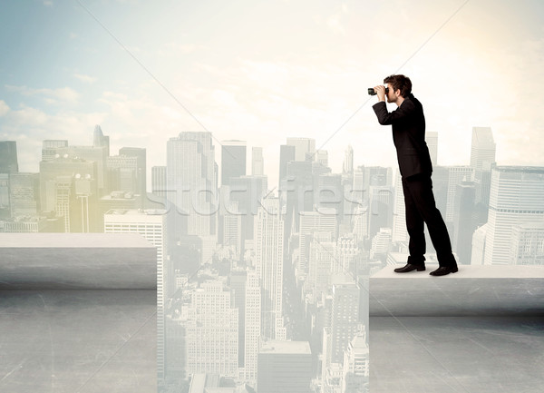 Businessman standing on the edge of rooftop Stock photo © ra2studio