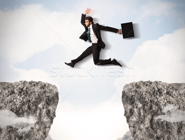 Funny człowiek biznesu skoki skał luka działalności Zdjęcia stock © ra2studio