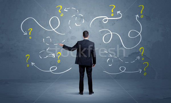 Unsure businessman with question marks Stock photo © ra2studio