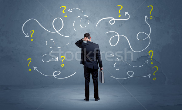 Unsure businessman with question marks Stock photo © ra2studio