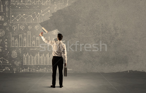 Salesman painting over charts on wall Stock photo © ra2studio