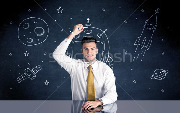 Sales person drawing helmet and space rocket Stock photo © ra2studio