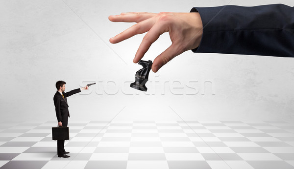 Businessman fighting against big chessman on a big hand Stock photo © ra2studio