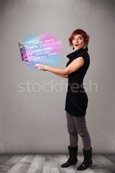 Casual woman holding laptop with exploding data and numers Stock photo © ra2studio