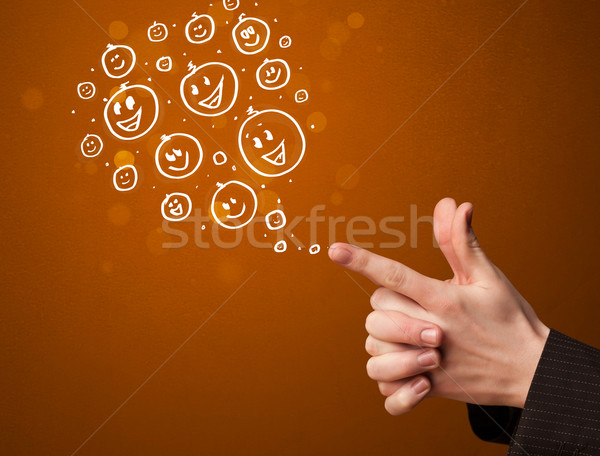Stock photo: Group of happy smiley faces coming out of gun shaped hands