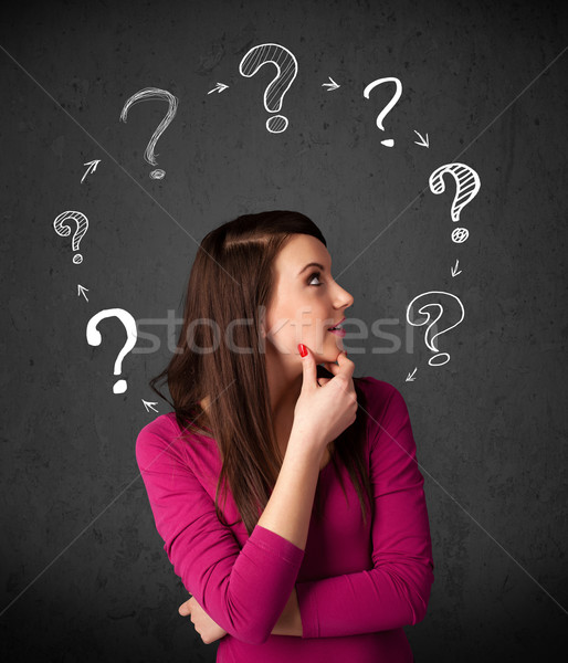 Stock photo: Young woman thinking with question mark circulation around her h