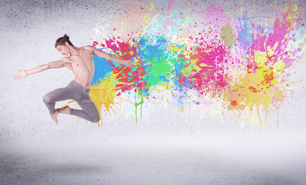 Modern street dancer jumping with colorful paint splashes Stock photo © ra2studio