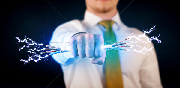 Business person holding electrical powered wires Stock photo © ra2studio