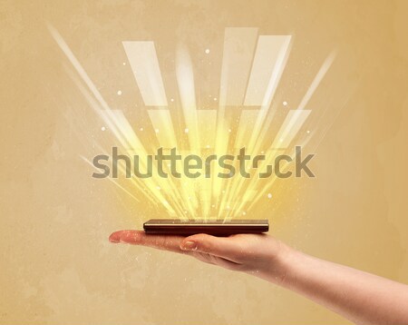 Hand with telephone and yellow light Stock photo © ra2studio