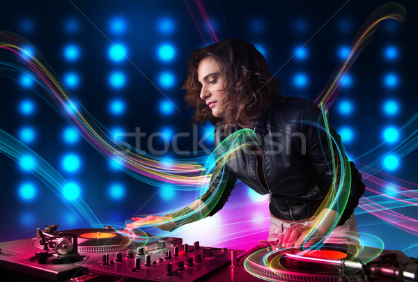 Young Dj girl mixing records with colorful lights Stock photo © ra2studio