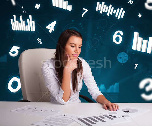 Young businesswoman sitting at desk with diagrams and statistics Stock photo © ra2studio