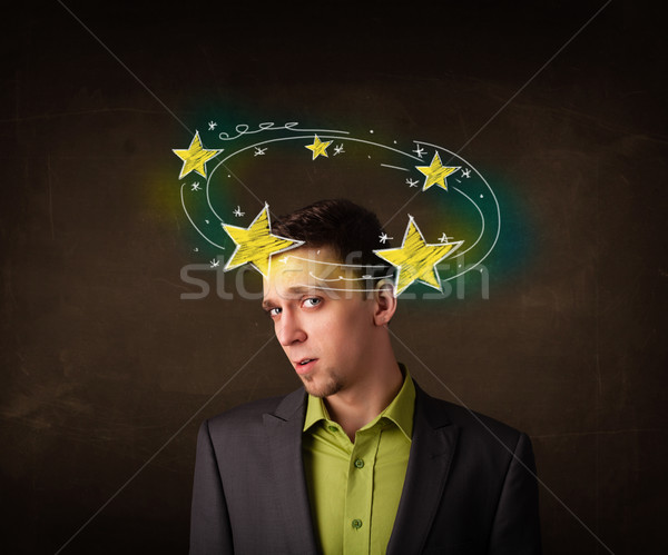 Young man with yellow stars circleing around his head Stock photo © ra2studio